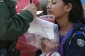 Salvadoran immigrant watches as a US Border Patrol agent records family information